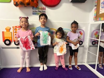 A group of children holding up the artwork they made