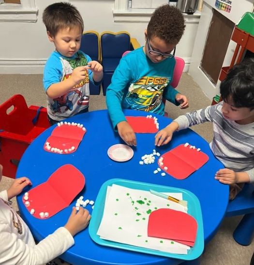 Children working with craft materials at the activity table