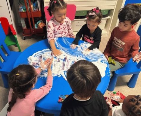 Children exploring shaving-cream sensory play together