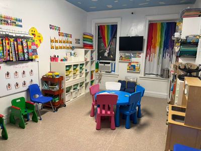 The classroom reading corner with low chairs, tables and a book display